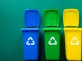 Trzy kolorowe kosze na śmieci: niebieski, zielony i żółty, z symbolami recyklingu. Pytanie: gdzie wyrzucać jednorazówki?