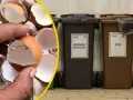 Skorupki jajek w dłoni obok koszy na odpady: zmieszane i bio.