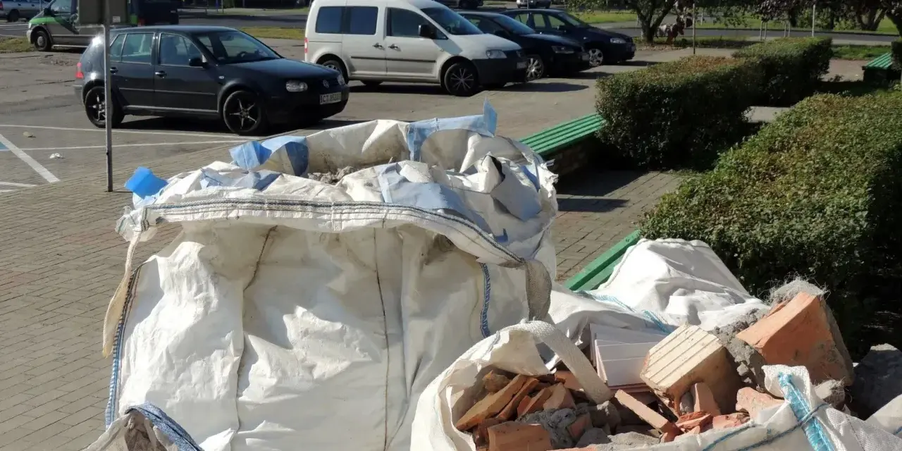 Duże białe worki z gruzem i cegłami, czekające na wywóz. Pytanie: gdzie wyrzucić worki po cemencie?