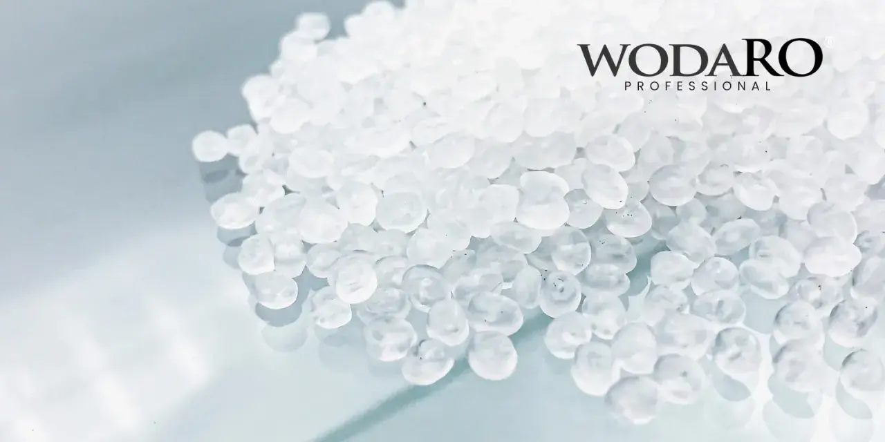 Granulat polipropylenowy WODARO PROFESSIONAL. Czyste, białe granulki tworzą tło dla logo.