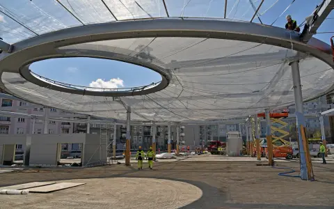 Budowa zadaszenia z folii etfe. Pracownicy w kaskach nadzorują montaż lekkiej, półprzezroczystej membrany.
