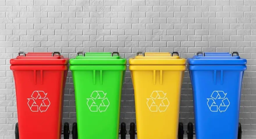 Czerwony, zielony, żółty i niebieski pojemnik na śmieci z symbolem recyklingu. Różne kolory pojemników na śmieci ułatwiają segregację.