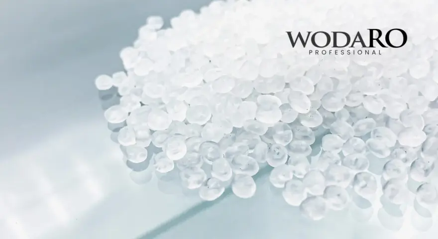 Granulat polipropylenowy WODARO PROFESSIONAL. Czyste, białe granulki tworzą tło dla logo.
